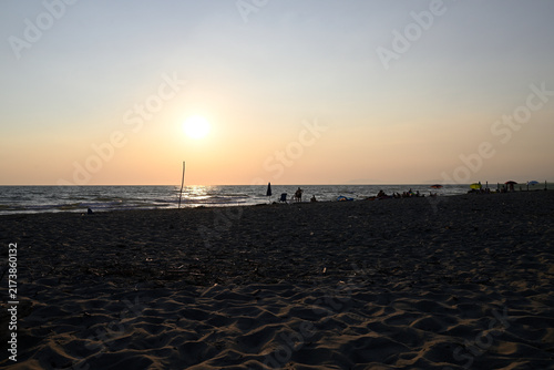 People enjoying sundown at tuscany beach. Togetherness at italian beach. Marina di Torre del LAgo, Tuscany, Italy, Europe.