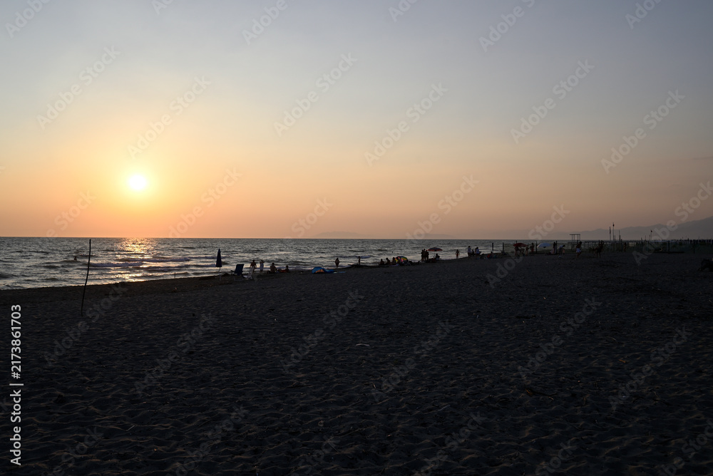 Obraz premium People enjoying sundown at tuscany beach. Togetherness at italian beach. Marina di Torre del LAgo, Tuscany, Italy, Europe.