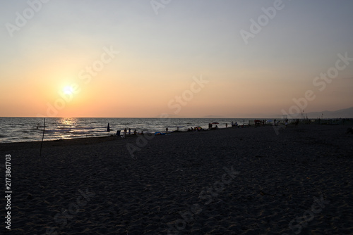 People enjoying sundown at tuscany beach. Togetherness at italian beach. Marina di Torre del LAgo, Tuscany, Italy, Europe.