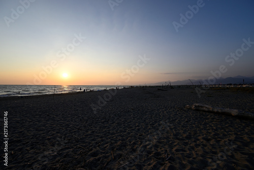 People enjoying sundown at tuscany beach. Togetherness at italian beach. Marina di Torre del LAgo, Tuscany, Italy, Europe.