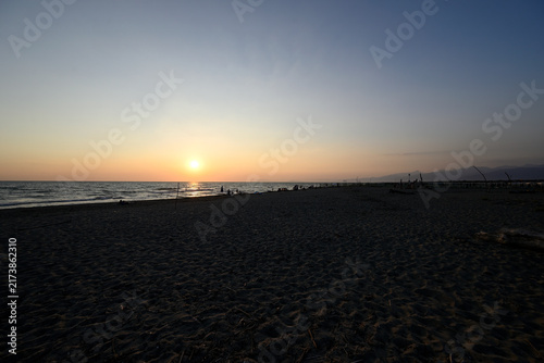 People enjoying sundown at tuscany beach. Togetherness at italian beach. Marina di Torre del LAgo, Tuscany, Italy, Europe.