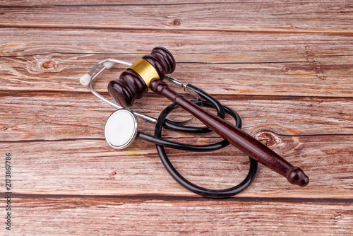 Fotografie Direct angle of a mahogany judge gavel and stethoscope on rustic wood