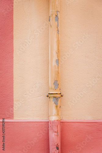 Pink and cream wall with a descending gutter. Graphic wall