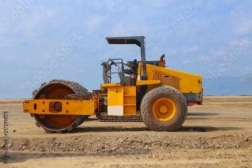 Cuadro en lienzo road roller with yellow color, on construction site and sky background