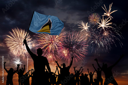 Silhouette man with flag of Saint Lucia and Holiday fireworks