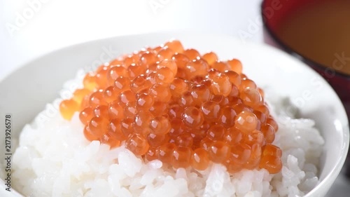 Fresh soy-marinated salmon roe displayed in transparent glass bowl with glossy finish