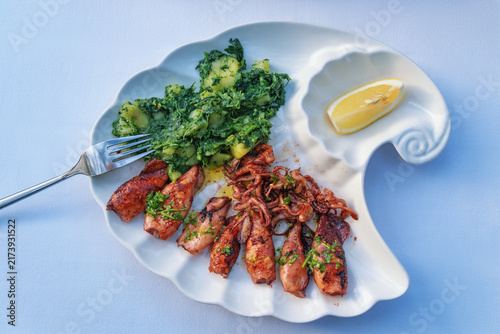 Balkan cuisine. Grilled squids with chard leaves and potatoes
