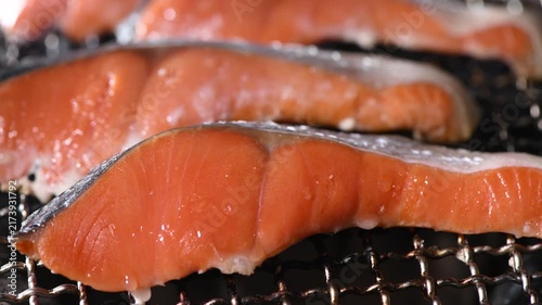 Fresh salmon fillet charcoal grilling on traditional Japanese shichirin with open flame