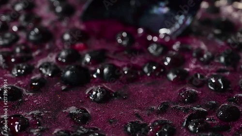 Fresh blueberries and rich purple juice boil and bubble while making homemade berry jam.