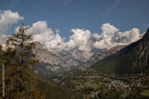 Alpine valley landscape with high mountains and clouds