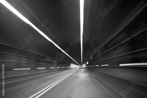 Driver speeding through dark highway tunnel with motion blur
