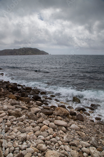 Rocky beach with waves breaking on overcast day