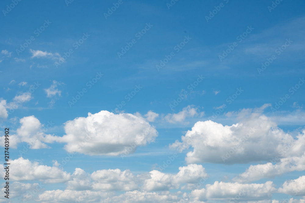 Obraz premium Horizontal bright blue sky featuring large fluffy white cumulus clouds and open clear space. Great for graphic design backgrounds, sky overlays, and summer weather-themed stock imagery.