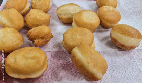 Freshly fried golden home-made donuts on a paper towel