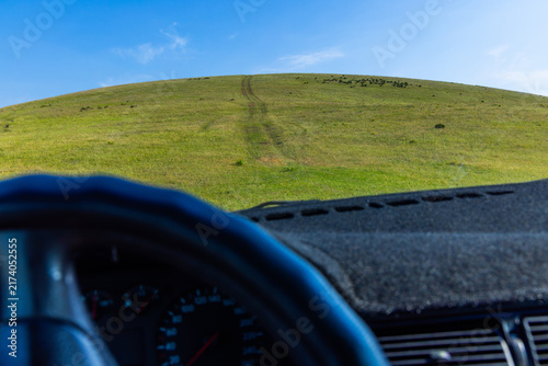 Photography View from vehicle towards green hillside on sunny day