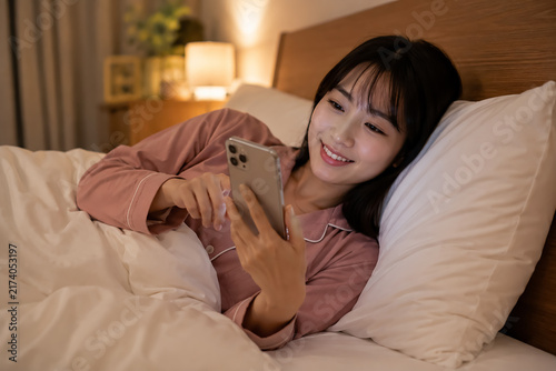 Tapety artystyczne スマホに夢中で夜更かしする日本人の若い女性
