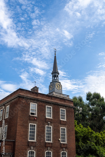Konstfotografi Historic Brick Building With Clock Tower Under Blue Sky and Morning Clouds