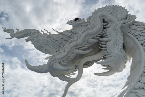 Photography Intricate white dragon sculpture against a cloudy sky