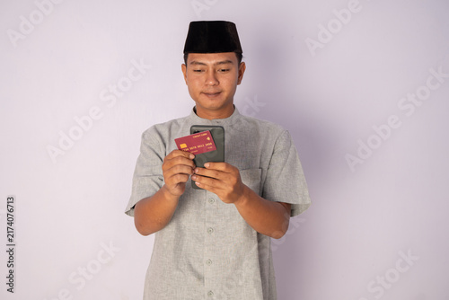 Cuadro en lienzo Man Holding Phone and Identity Card While Wearing Traditional Attire in Studio S