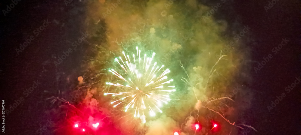 Obraz premium Fuegos artificiales dorados y destellos que iluminan el cielo nocturno en una espectacular exhibición pirotécnica de celebración.
