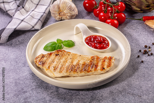 Canvas Print Grilled chicken breast with tomato sauce and basil on plate