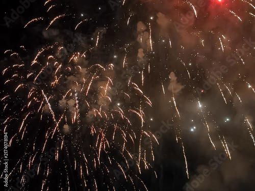 Fotografie Fuegos artificiales dorados y destellos que iluminan el cielo nocturno en una espectacular exhibición pirotécnica de celebración