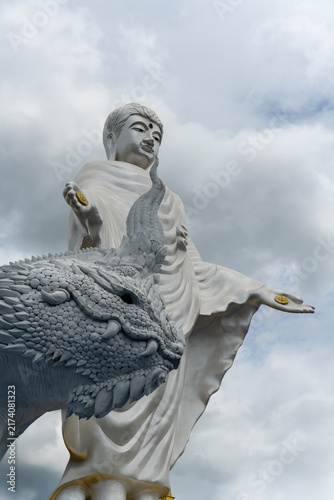 Canvastavla Majestic white statue of Buddha with a mythical dragon guardian against a cloudy