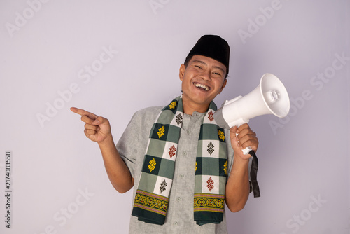 Cheerful Young Man in Traditional Attire Holding a Megaphone and Smiling with Joyful Expression