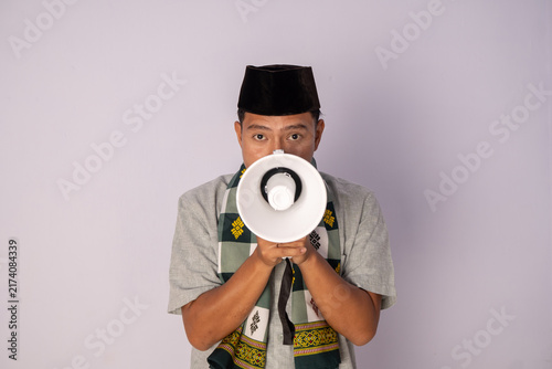 A Young Man in Traditional Attire Holding a Megaphone on a Plain Background for Advocacy