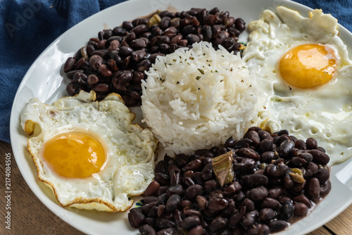 Rice, black beans, and fried eggs on a plate