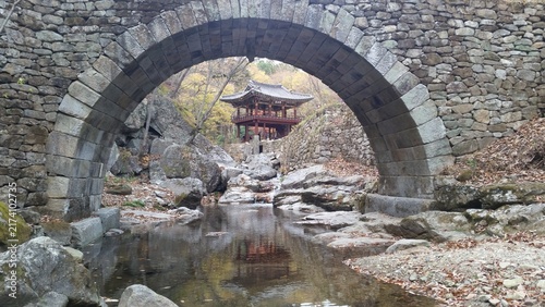 Obraz na płótnie A scenic view of Seonseongyo, a designated treasure rainbow bridge at Suncheon Seonamsa Temple, with a traditional pavilion behind it