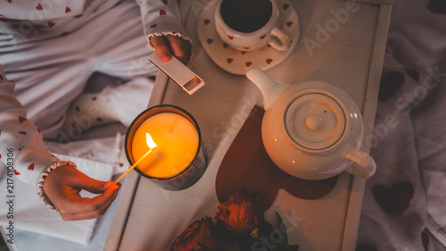 Foto Cozy morning ritual with tea, candle, and roses on a tray