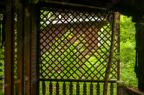 Abandoned overgrown mansion with spiral staircase, old car and ruined interior