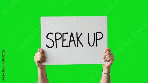 Hands holding a banner sign with the text speak up on a green screen chroma key background