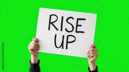 Hands holding a banner sign with the text rise up on a green screen chroma key background