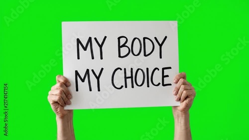 Hands holding a banner sign with the text my body my choice on a green screen chroma key background