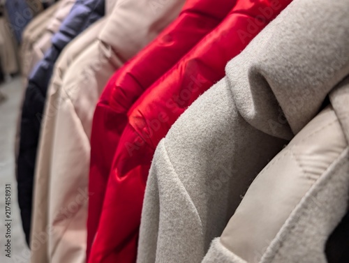 Foto Close-up of coats on a clothing rack in a store, including wool and quilted jack