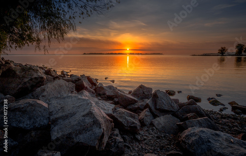 Canvastavla Sunset path of light across the water above a boulder strewn shore, Dnipro River