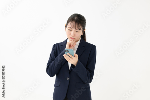 Obraz na płótnie スマホを見て悩む女性