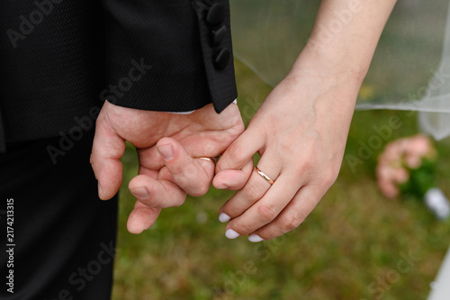 Cuadro en lienzo Newlyweds holding hands little fingers with wedding rings for romantic marriage