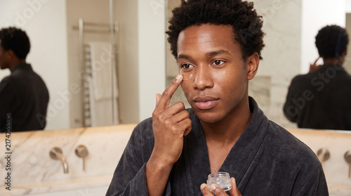 Careful African American Man Applying Hydrating Eye Gel in Bathroom