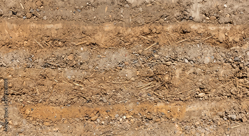 Horizontal layers of compacted soil and straw in rammed earth wall texture