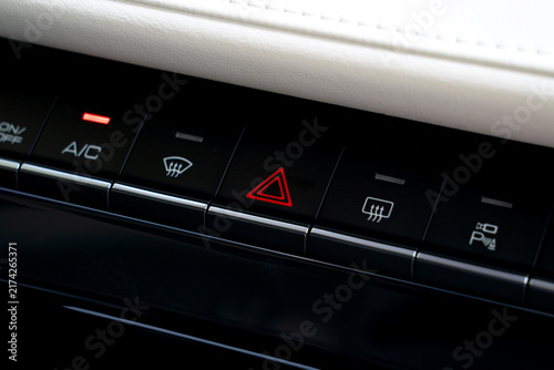 Modern Car Dashboard Control Panel with Illuminated Red Hazard Light Button and Climate Controls