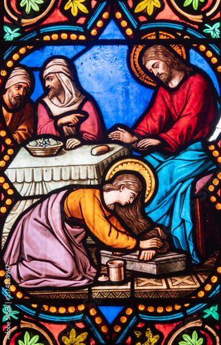 Fotografie Stained glass window depicts Mary Magdalene kneeling to anoint the feet of Jesus