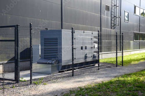 Foto Outdoor Standby Diesel Generator Unit Enclosed Behind Safety Fence