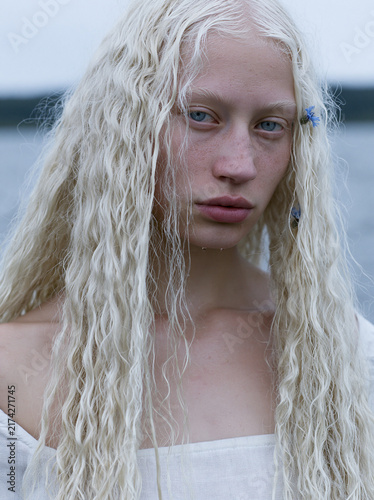 Haunting cinematic portrait of the Maiden of the Neman, an extraordinarily beautiful 23 year old Belarusian woman standing in the river
