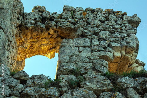 Quadro su tela Stone ruins stand in sunlight under a clear blue sky at a historical site