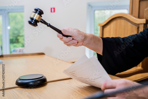 Quadro su tela Judge Holding Gavel and Reading Document at Courtroom Desk