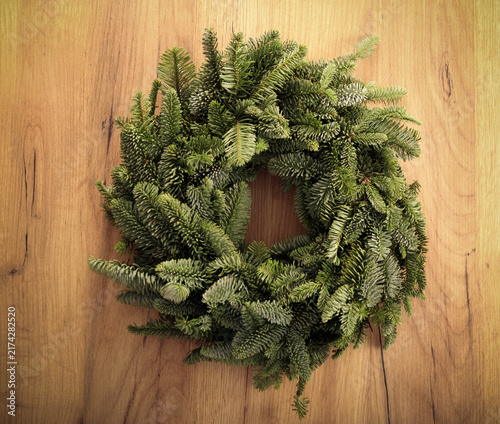 Christmas green wreath over wood
