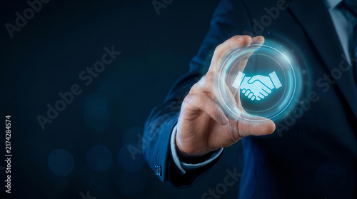 Hand holding holographic handshake sphere business deal